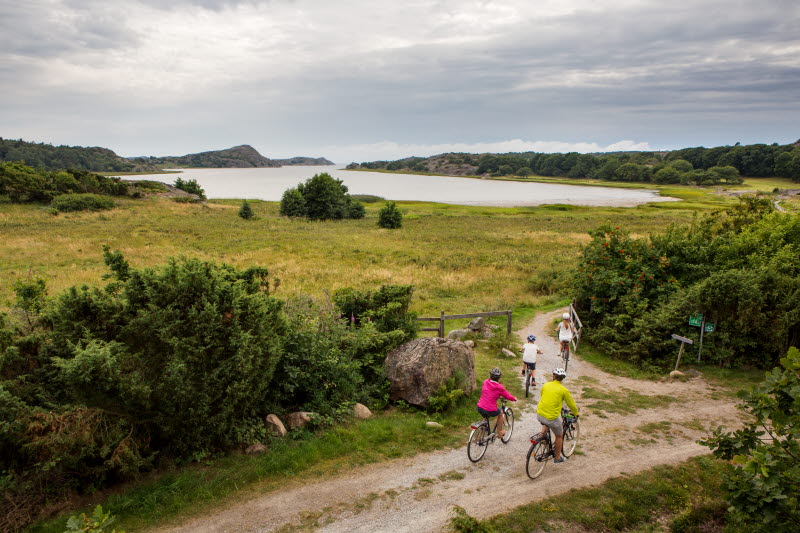 Family cycle on dirt road along  pastures and water at Pilane -  Photo Cred Roger Borgelid